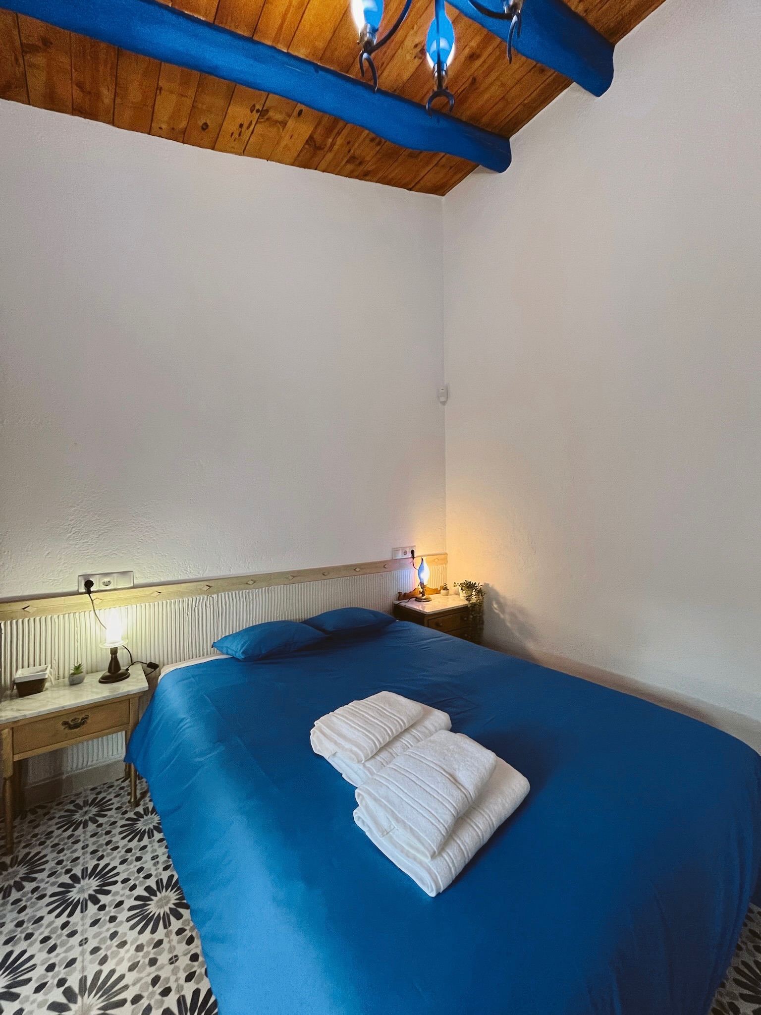 Cama azul preparada para huéspedes de La Antigua Estación